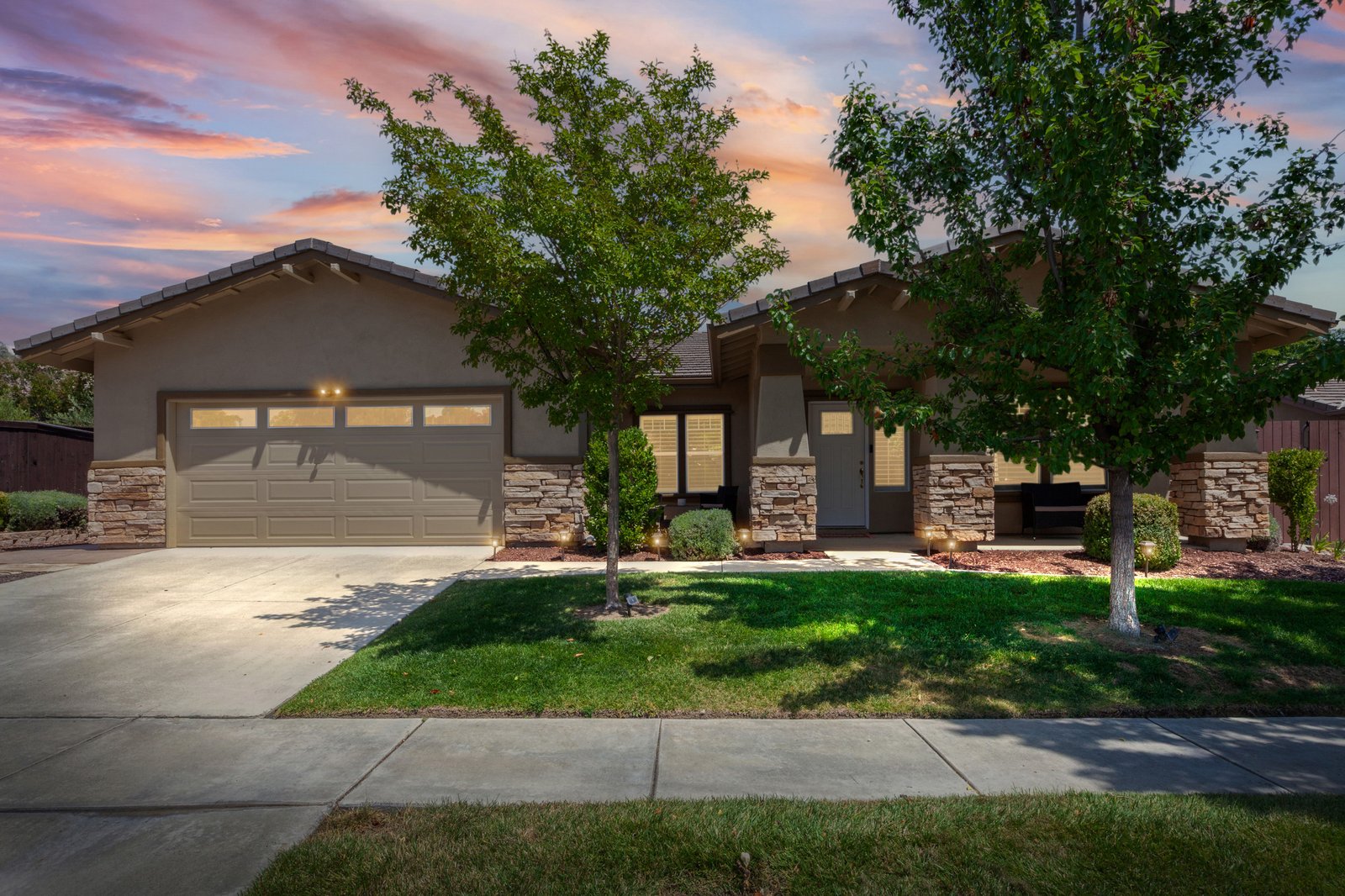 Exterior of 1204 Grassy Hollow, a single-story home with stone accents and a two-car garage in Paso Robles, CA
